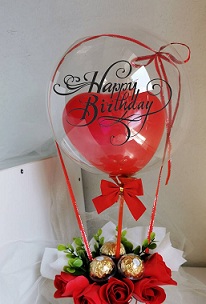 Stuffed red heart balloon in a Printed balloon with happy birthday and 5 red roses inside 3 Ferrero chocolates in a basket wrapping in red ribbon